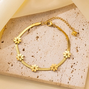 Detalle de pulsera de cadena de serpiente con margaritas bañada en oro 18K y dije de corazón