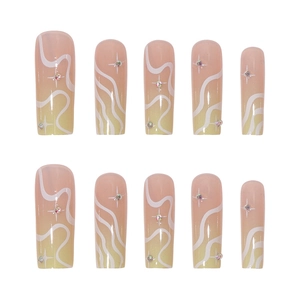 Long coffin press-on nails with nude yellow gradient, white wavy lines and rhinestones