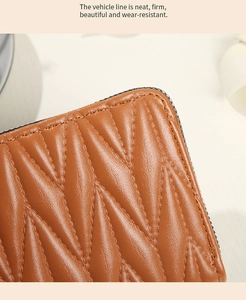 Close-up of brown leather wallet featuring neat V-shaped quilted stitching and high texture