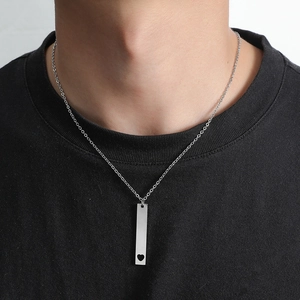 Polished silver stainless steel bar necklace with heart cutout on a male model