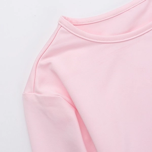 Macro shot of pink knit dress neckline and shoulder seams showing high-quality stitching