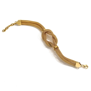 Detailed macro view of a gold-tone twisted mesh chain bracelet with lobster clasp