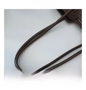 Detail shot of the durable dark brown leather handle with premium white contrast stitching