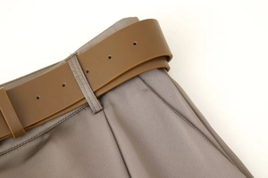 Close-up of waist tailoring and matching belt on khaki satin wide-leg trousers
