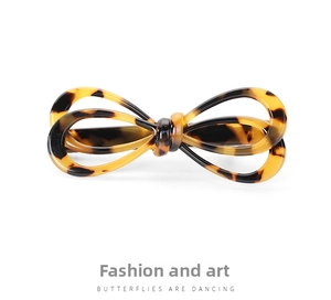 Detail view of a tortoise shell acetate bow hair clip with vintage texture and glossy finish