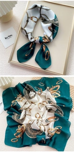 Detailed view of emerald and cream silk scarf featuring equestrian chain motifs