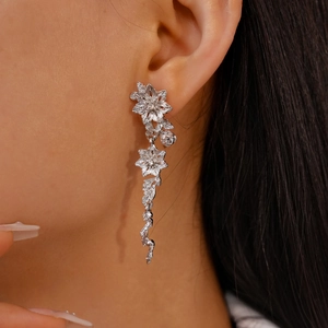 Vue détaillée des boucles d'oreilles argentées avec fleurs et pompons de vigne