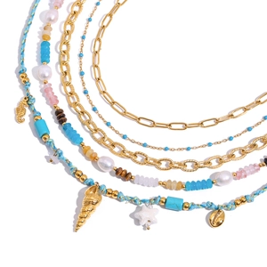 Collier multi-rangs en acier doré avec pierres naturelles et coquillages sur fond blanc