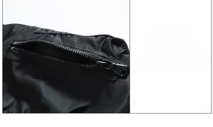 Detail einer matt-schwarzen Reißverschlusstasche an einem hochwertigen Nylon-Bomberjacken-Ärmel