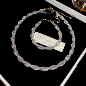 Detailed shot of silver twist rope necklace and bracelet set with starry glitter texture