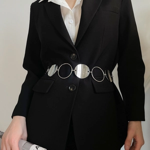 Detail of silver oval metal waist chain with brushed texture on black blazer outfit