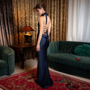 Detail of navy blue satin dress featuring cross back straps and silky texture