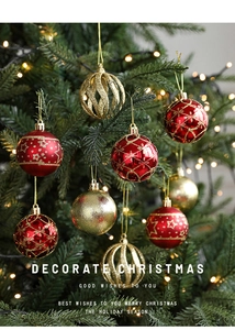 Detail of red and gold Christmas ornaments with glitter patterns hanging on a tree