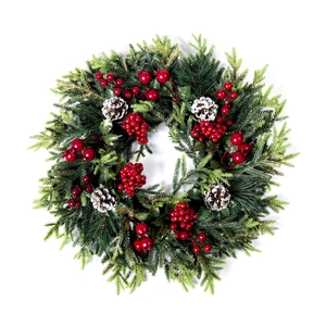 Classic Christmas wreath with green pine needles, red berries and snow-dusted pinecones