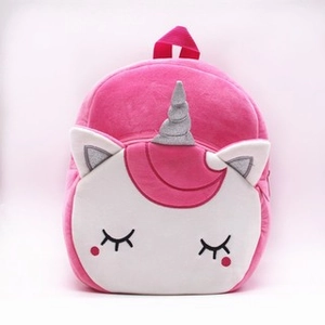 Detail of plush unicorn backpack featuring silver glitter horn and cute embroidered face