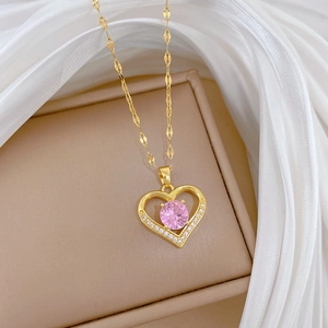 Titanium steel heart necklace with pink gem and diamonds on beige jewelry box