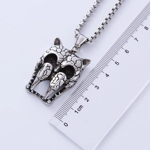Detailed measurement of vintage silver wolf skull pendant with dimensions on a ruler