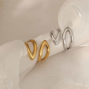 Polished double-layered V-shaped stainless steel rings in gold and silver on white silk