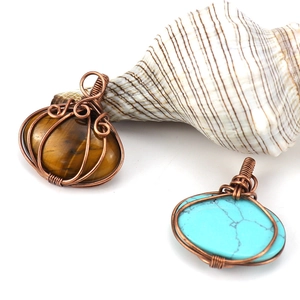 Handmade copper wire wrapped tiger eye and turquoise pendants on white background