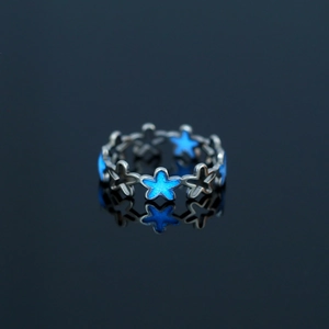 Macro shot of 304 stainless steel star ring with glowing blue inlay and reflective finish