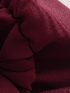 Detailed macro view of high-quality burgundy knitted fabric texture and soft drapes