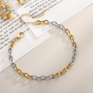 Detail of two-tone gold and silver link chain with lobster clasp on vintage book page
