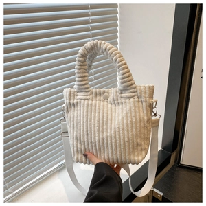 Detail view of white corduroy bucket bag texture with resin snap closure and handle
