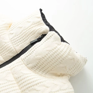Chic beige cable knit puffer jacket with black zipper detail for winter fashion style