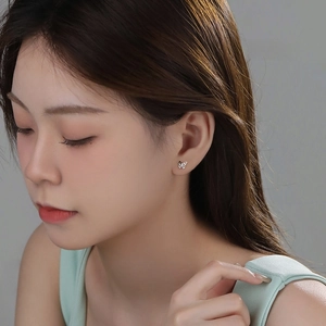 Minimalist S925 sterling silver butterfly stud earrings worn by a model in a side view