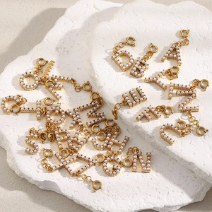Close-up of gold 18K plated initial letter charms with pearls and lobster clasps
