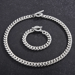 Detailed view of silver skull Cuban chain set with OT toggle clasp on dark starry background