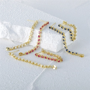 Detailed view of three pairs of gold long chain earrings with clear, pink, and blue crystals