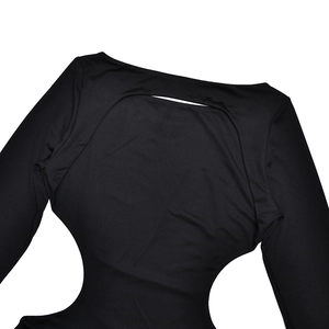 Détail de la robe noire à manches longues montrant le tissu élastique et le dos nu ajouré