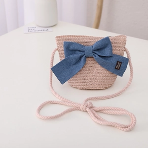 Detail of pink straw crossbody bag with large blue bow and handmade label for kids