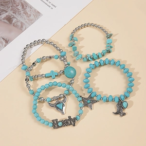 Detail of Western turquoise bracelet set with bull head and star charms in vintage silver