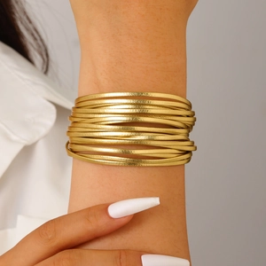 Macro detail of Bohemian multilayer gold textured metal tube bracelet with magnetic clasp
