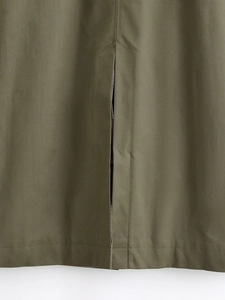 Detail of the back slit hem and stitching on this army green reversible trench coat