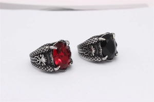 Detailansicht eines gotischen Drachenkralle-Rings mit roten und schwarzen ovalen Steinen