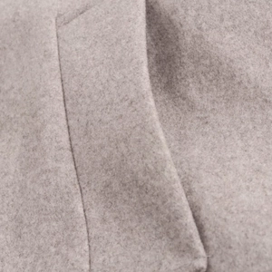 Close-up of gray wool coat fabric texture and precise stitching on the horizontal pocket