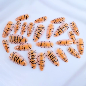 Long almond tiger print press-on nails with glossy orange and black animal pattern