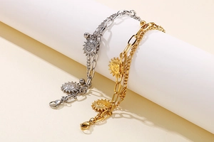 Detail of double-layer stainless steel bracelets with sun pendants in gold and silver