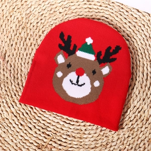 Close-up of red knitted Christmas beanie featuring a cute cartoon reindeer pattern