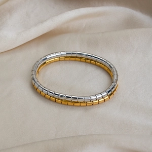 Set of gold and silver Tubogas elastic stainless steel bracelets on white silk