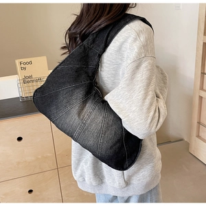 Sac croissant en denim noir délavé avec surpiqûres dans un décor intérieur de style vie