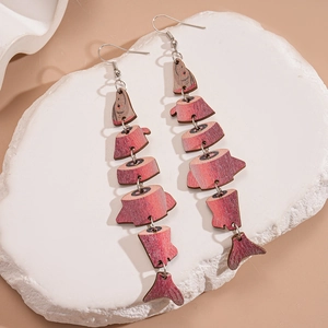 Detail of fish-shaped wooden earrings with red textured print and metal ring links