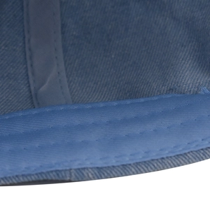 Macro shot of dual-tone blue washed denim fabric with detailed reinforced stitching