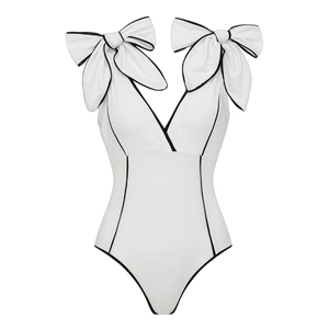 Detail of white deep V-neck swimsuit with large black bow decorations on shoulders