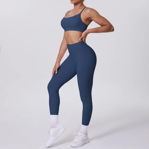 Vue latérale d'un ensemble de yoga bleu foncé avec brassière et legging taille haute