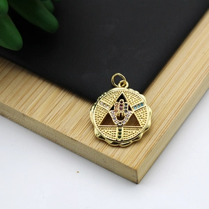 Macro shot of 18K gold-plated Hamsa hand pendant with multi-colored stones on wood