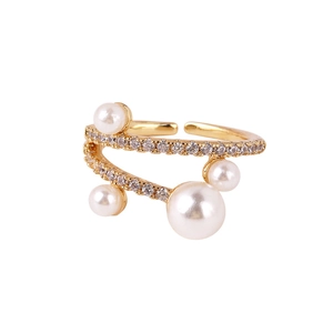Detailed view of a gold open ring featuring four white pearls and pavé micro-zirconia stones